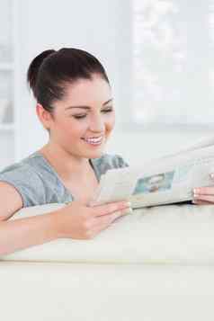 微笑女人阅读新闻坐着沙发上