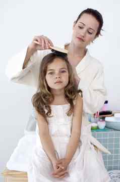 妈妈。刷牙女儿的头发