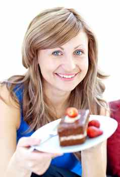 微笑女人持有一块巧克力蛋糕