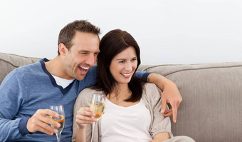 快乐的夫妇喝香槟沙发