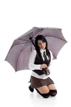 年轻的女跪着地板上持有伞