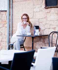 年轻的女人喝咖啡户外夏天