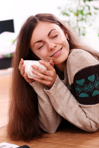 年轻的女人温暖的杯茶首页