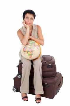 年轻的旅游女人坐在棕色（的）旅行手提箱