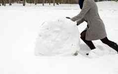 女人灰色外套推大雪卷冬天草地