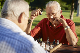 活跃的退休人高级但玩国际象棋公园