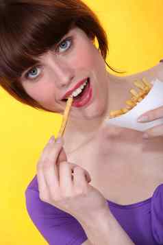 浅黑肤色的女人吃法国薯条