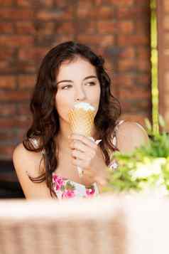 肖像年轻的快乐女人吃冰淇淋
