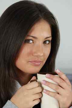 年轻的女人美丽的脸茶咖啡
