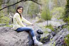 女孩坐着岩石悬崖边缘