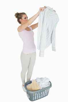 女人检查衬衫洗衣篮子