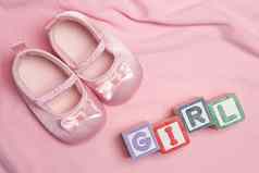 粉红色的婴儿拖鞋块拼写女孩