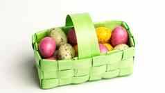 斑点色彩鲜艳的复活节鸡蛋绿色篮子