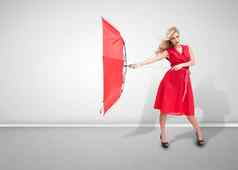 美丽的女人穿红色的衣服持有伞