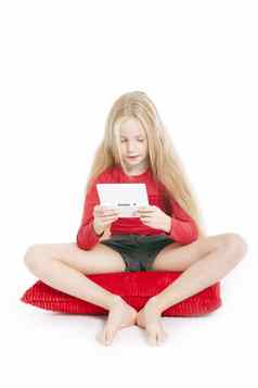 年轻的女孩红色的枕头玩电子游戏