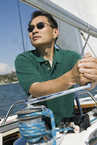 亚洲男人。提高帆帆船清晰的天空