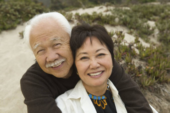 成熟的夫妇拥抱海滩微笑肖像