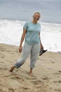 高级女人站光着脚海滩肖像