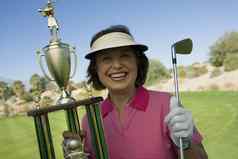 肖像快乐高级女人持有赢得奖杯高尔夫球