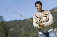 肖像快乐成熟的拉美裔男人。钓鱼阳光明媚的一天