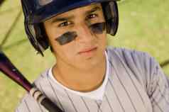 肖像年轻的高加索人棒球球员持有蝙蝠
