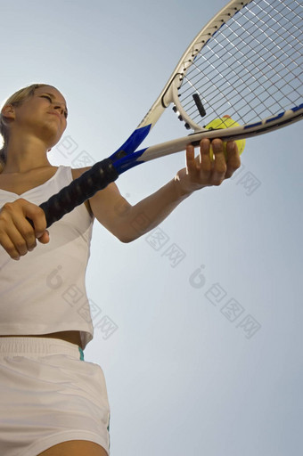 低角视图女<strong>网球</strong>球员准备服务清晰的蓝色的天空
