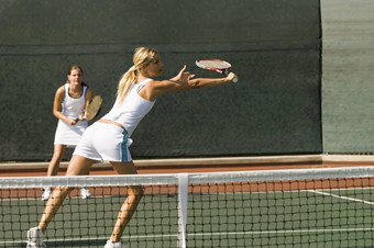 女<strong>网球</strong>球员伸展运动拍摄合作伙伴站背景