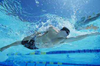 低角视图年轻的男人。游泳水下