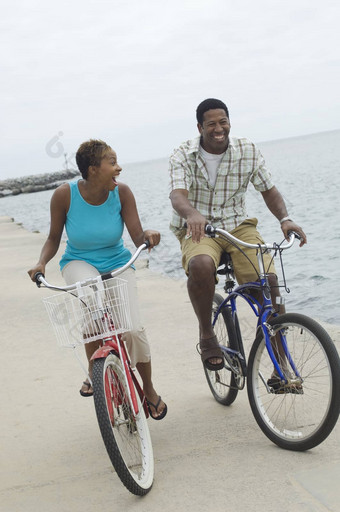 快乐非洲美国夫妇骑自行车海滩