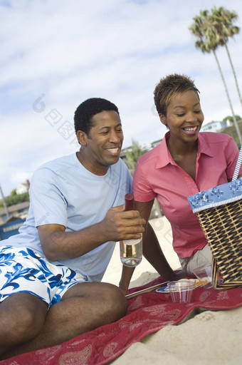 快乐非洲美国夫妇享受野餐海滩