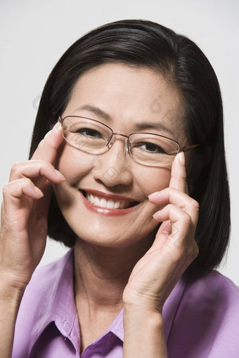 特写镜头肖像快乐中国人女人眼镜灰色背景