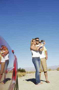 夫妇体育车采取照片一边沙漠路
