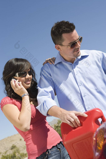 快乐年轻的女人谈话移动电话男人。加油<strong>车</strong>