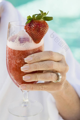 特写镜头高级女人的手持有玻璃草莓汁