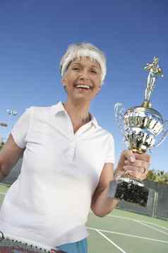 快乐高级女网球球员持有奖杯赢得