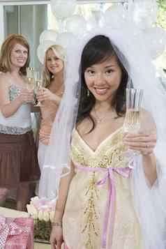 肖像年轻的快乐新娘持有香槟长笛朋友背景