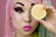 女人持有片柠檬前面眼睛