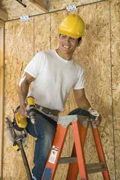 快乐中间岁的建设工人梯持有权力工具