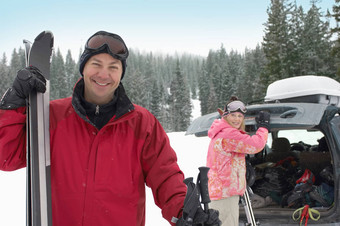 肖像快乐成熟的男人。持有滑雪女人背景