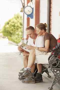完整的长度中间岁的夫妇阅读地图板凳上