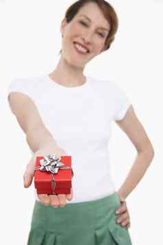 肖像年轻的女人提供小包装礼物白色背景