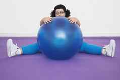 累了超重女人坐着锻炼球healthclub