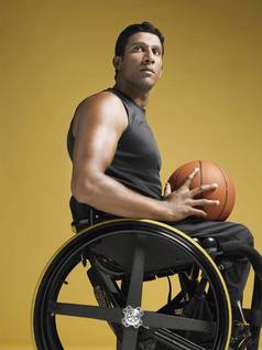 半身不遂运动员坐着轮椅持有篮球一边视图