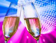 香槟长笛金泡沫使干杯闪闪发光的蓝色的紫罗兰色的迪斯科球背景