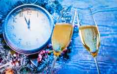 一年圣诞节午夜香槟长笛黄金泡沫使干杯蓝色的光时钟