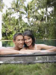 肖像快乐年轻的夫妇游泳池