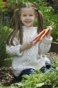 肖像女孩持有胡萝卜花园
