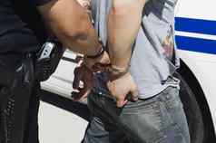 上腹部警察官逮捕年轻的男人。车