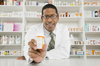 肖像非洲美国药剂师持有医学瓶