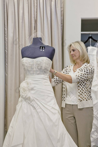 高级女老板调整婚礼衣服人体模型新娘商店